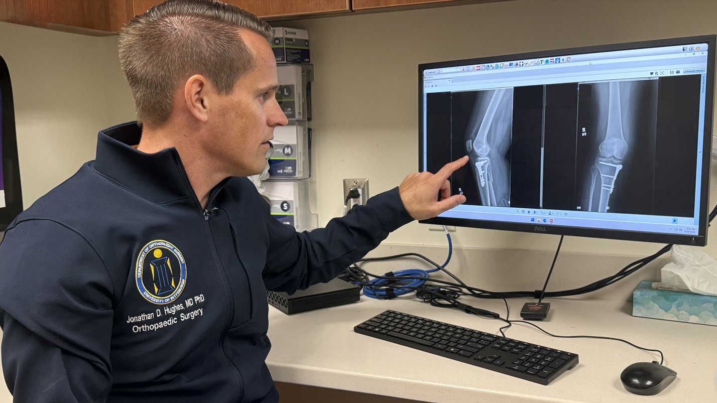 Dr. Hughes reviewing a patient's knee X-ray in clinic